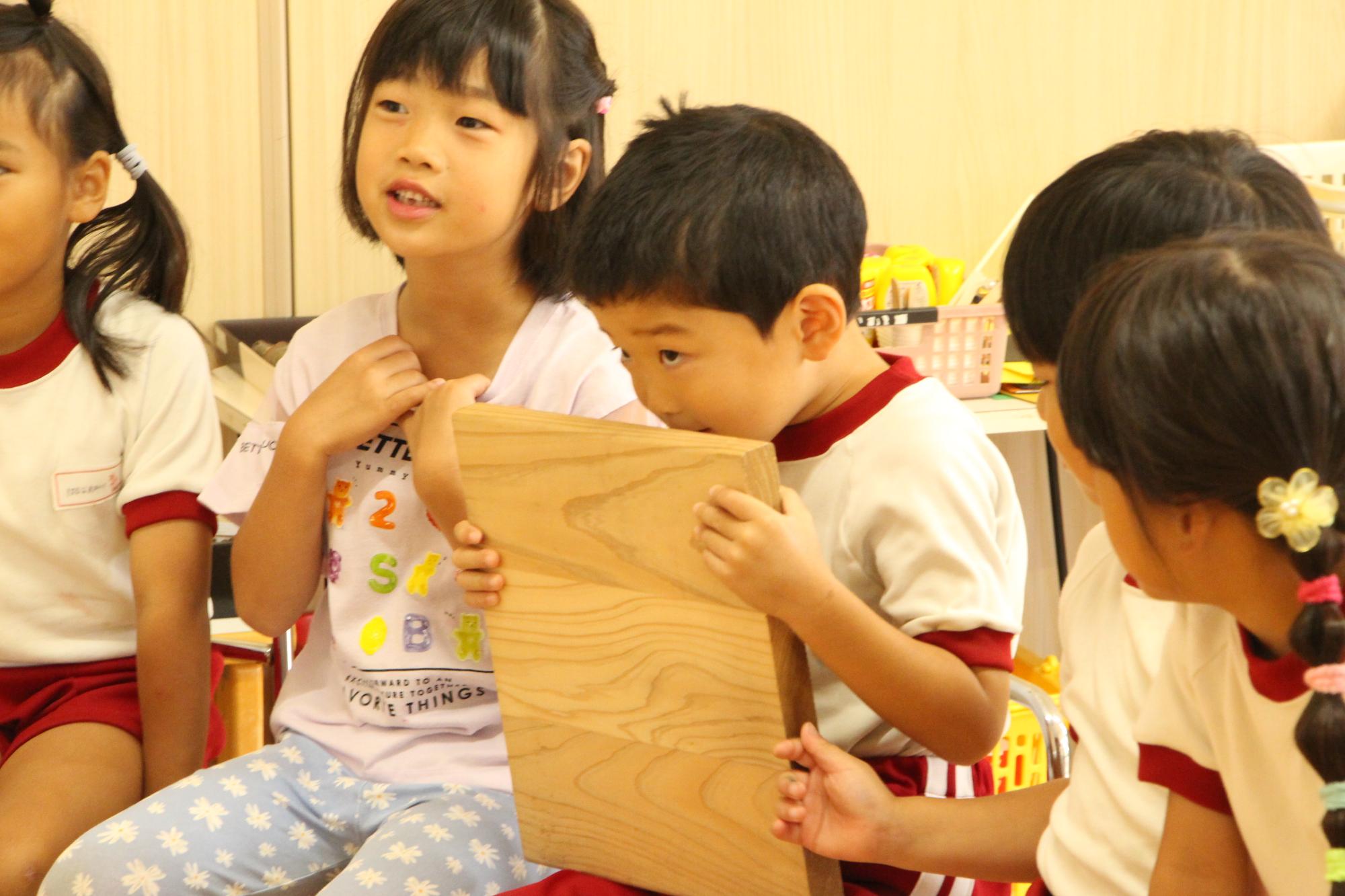 木の香りをかぐ園児の姿