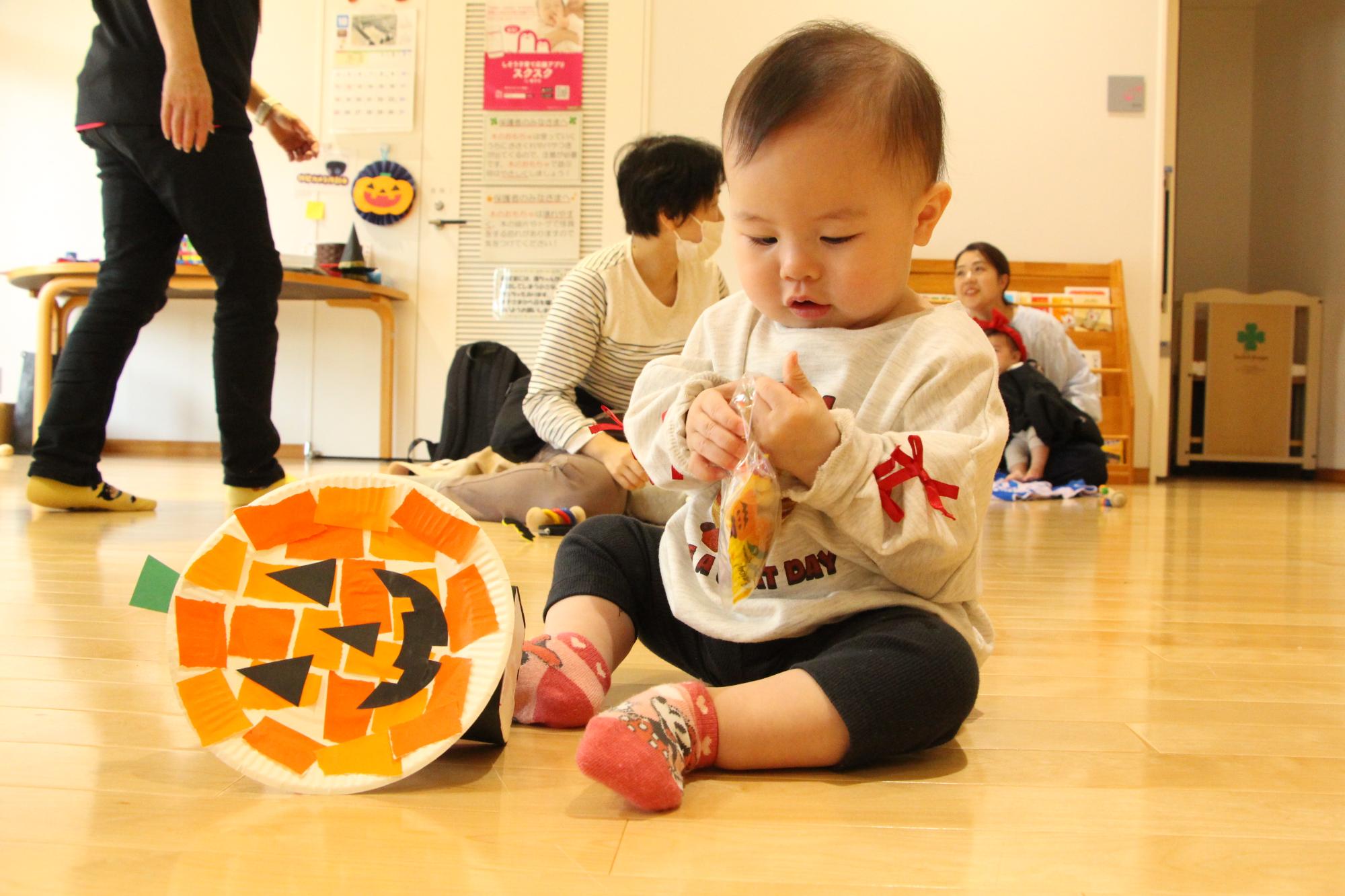 もらったお菓子が気になる赤ちゃんの姿