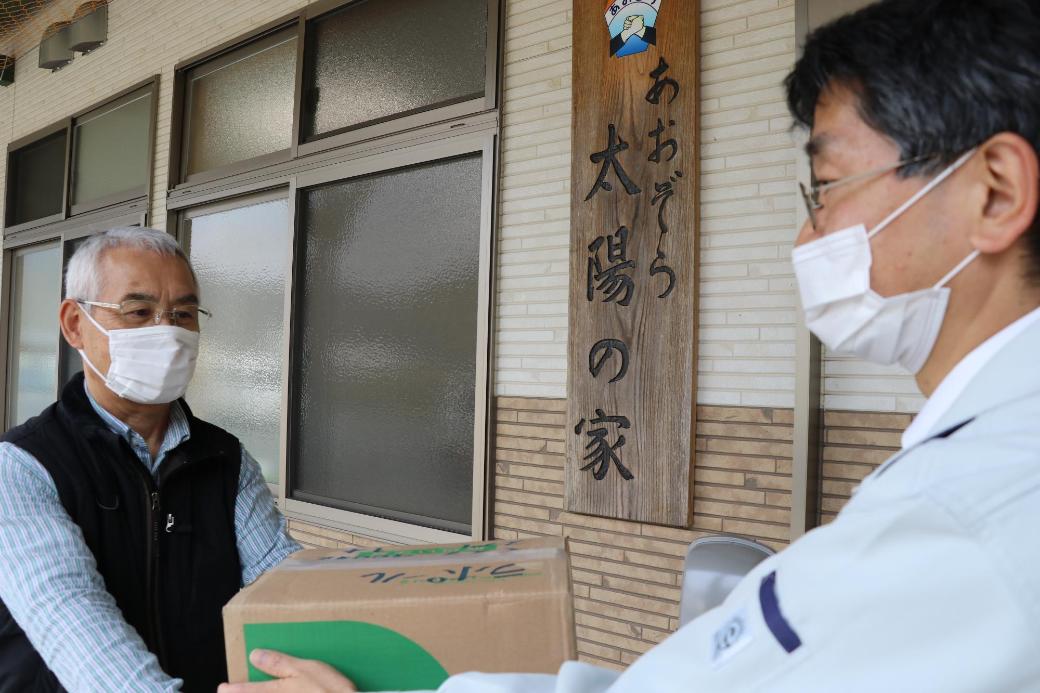 宍粟市役所職員が太陽の家の施設員にマスクをわたす写真