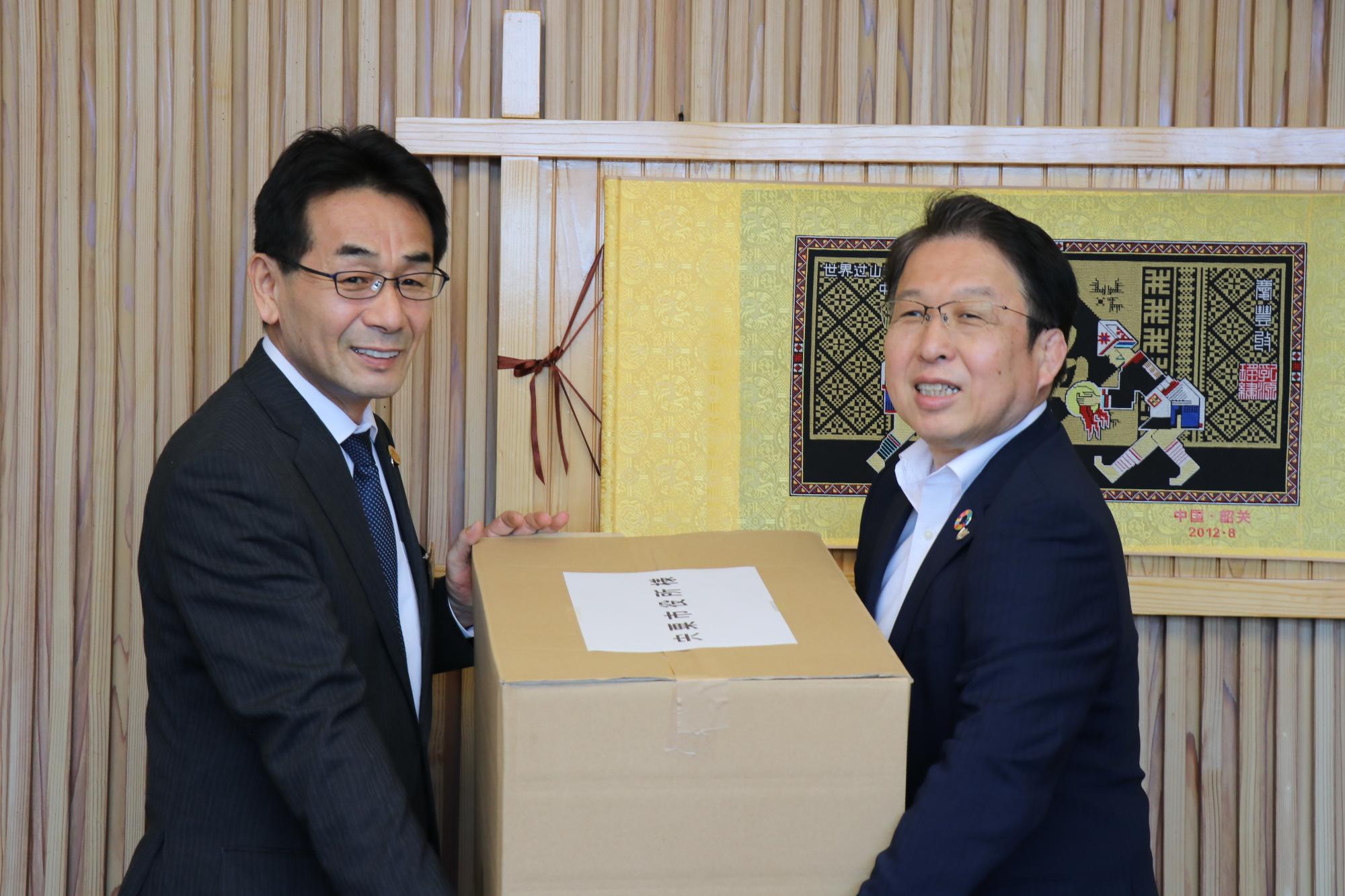 副市長と第一生命社長がマスクを手渡ししている写真