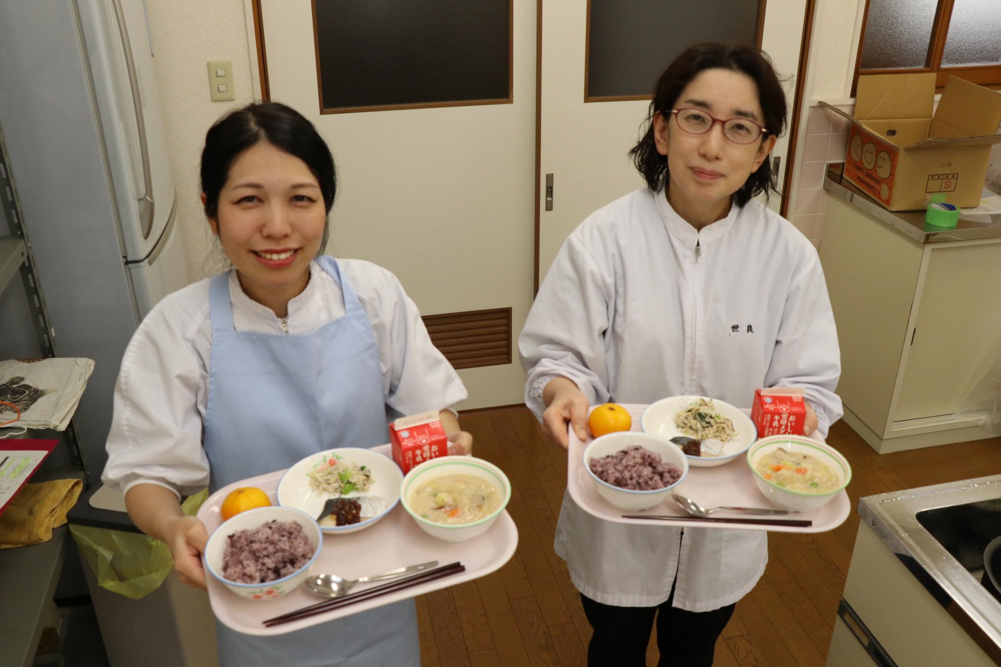 学校給食甲子園で発表する給食を手にする安原調理師と世良栄養教諭