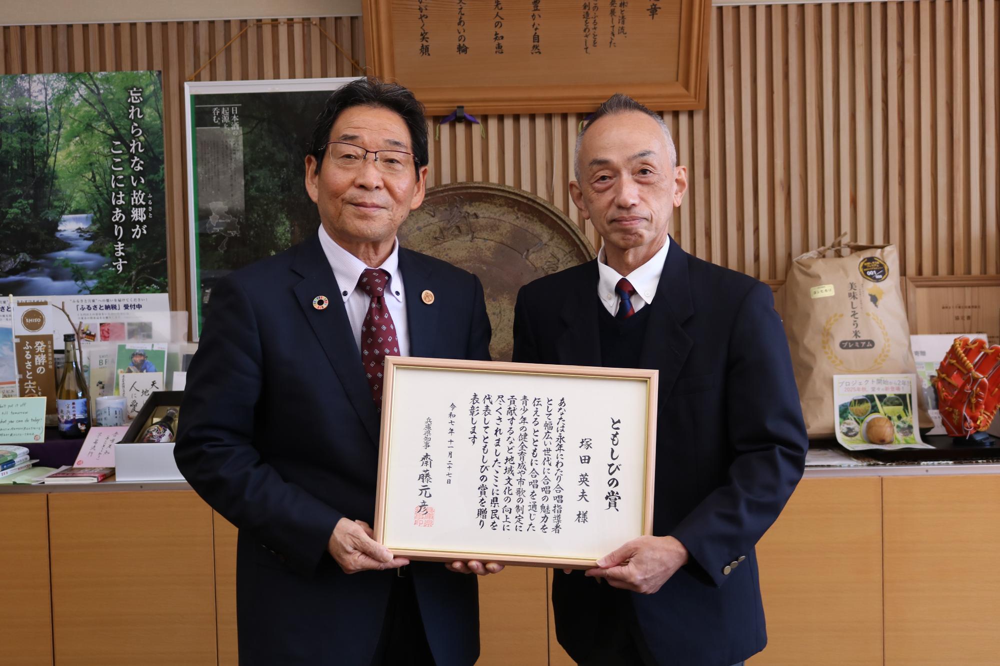 ともしび賞の賞状を手にする塚田さん