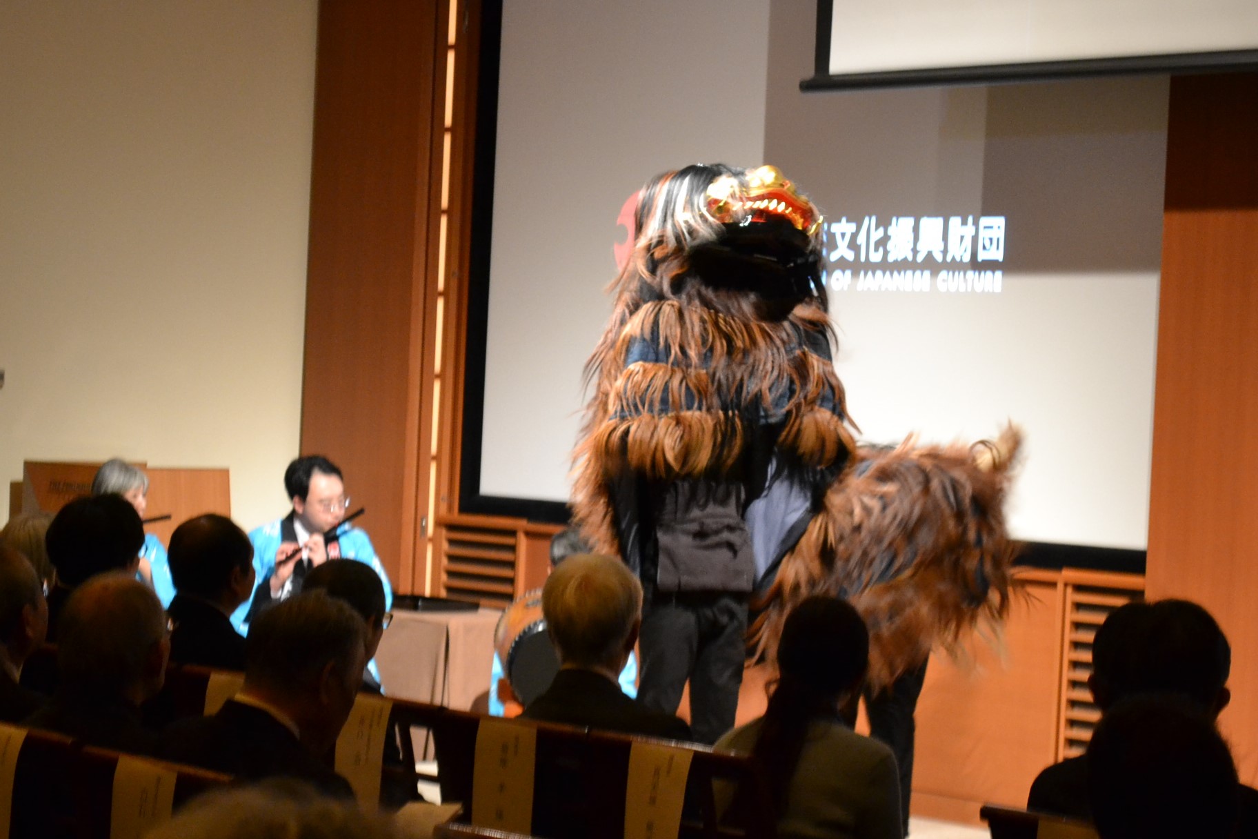 贈呈式の会場で、来場者を前に獅子舞を披露している写真