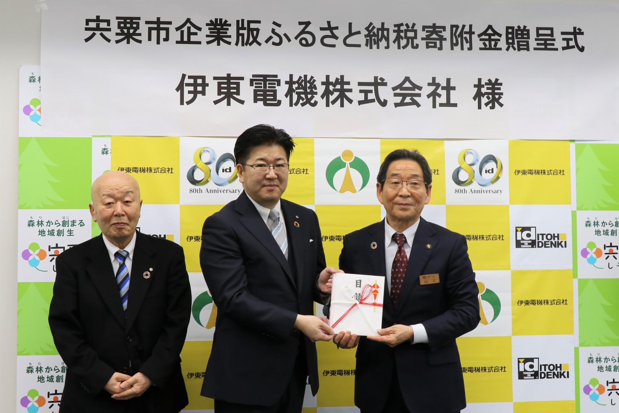 伊東社長（中央）より目録を受け取る福元市長
