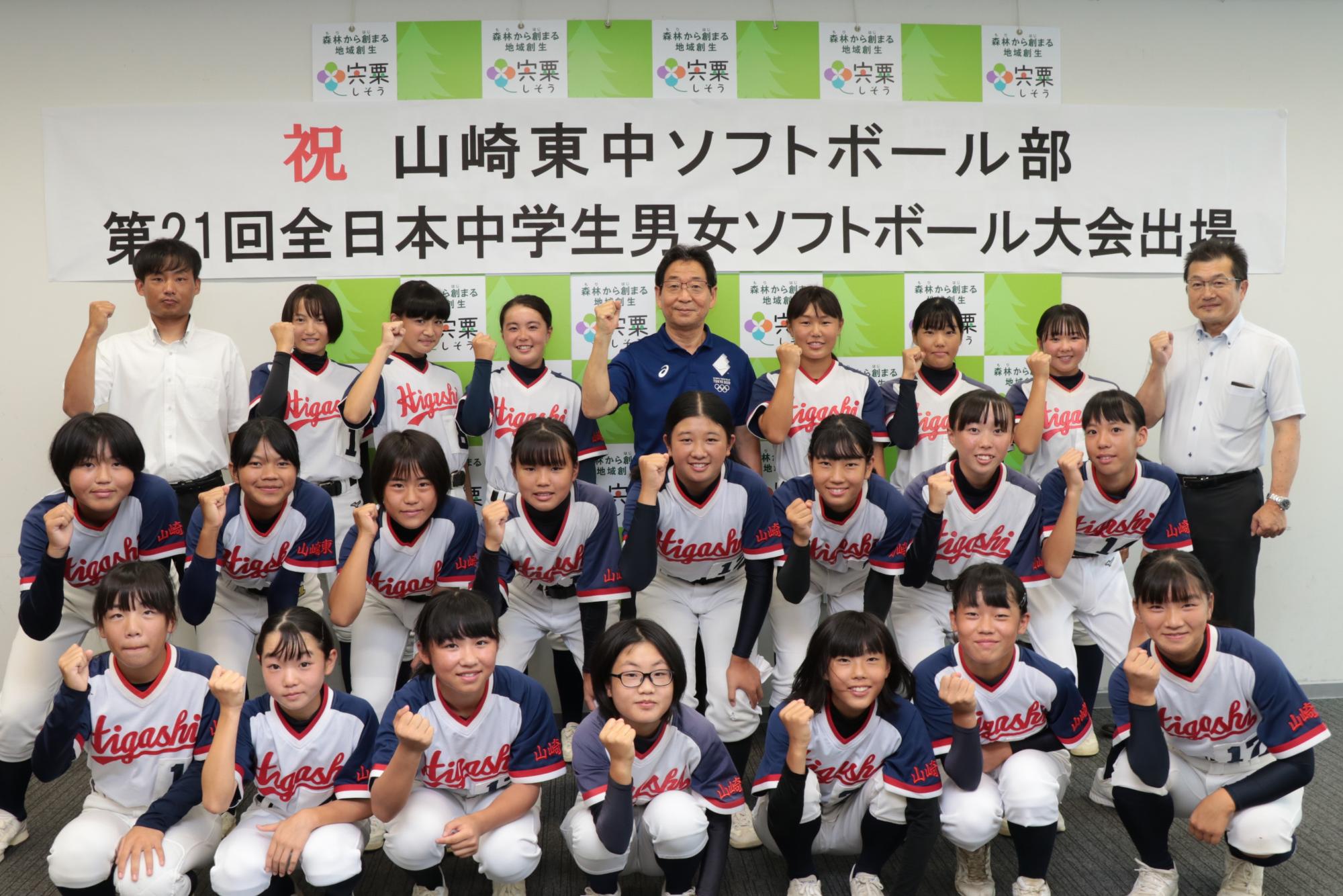 山崎東中学校ソフトボール部のメンバーが並んでガッツポーズをとる写真