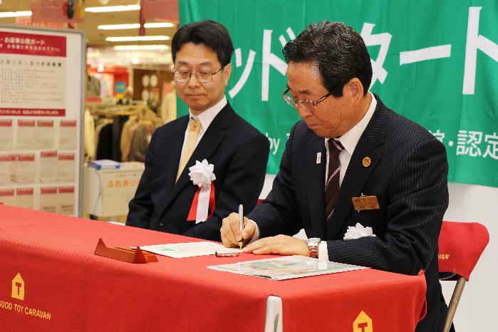 福元市長が東京おもちゃ美術館馬場副館長とともに宣言書に調印している写真