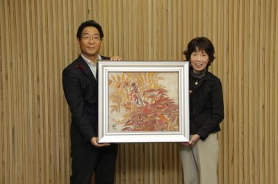 中野敏江氏より寄贈された絵画とともに記念撮影をする市長の写真
