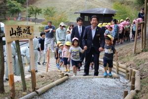 できたばかりの最上山公園遊歩道を子どもたちと市長が歩く写真