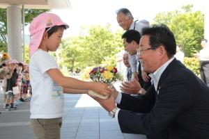 園児から手渡されたお花を受け取る市長の写真