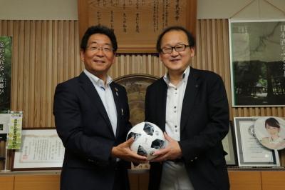 寄贈されたサッカーボールを手に記念撮影する市長の写真