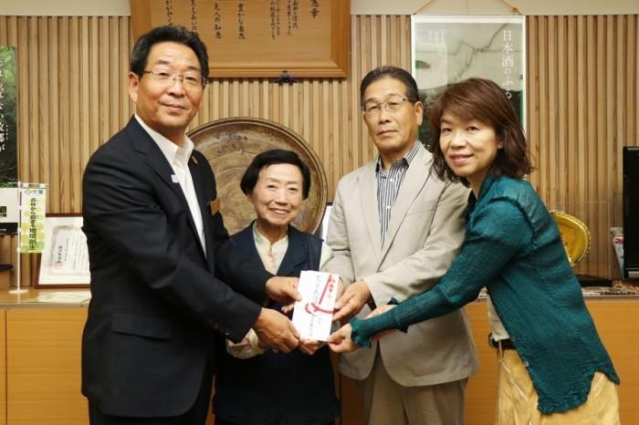茶華道協会の方々と手渡された義援金を手に記念撮影する市長の写真