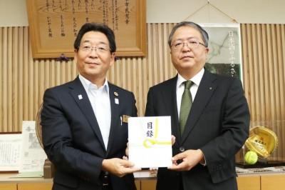手渡された目録を手に西日本建設業保証株式会社の関係者と記念撮影する市長の写真