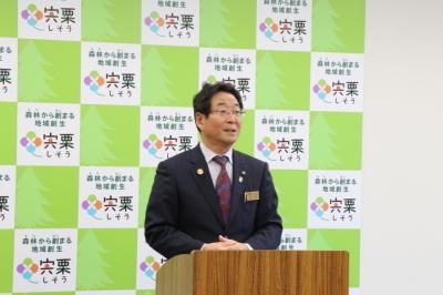 記者懇談会で演壇から挨拶をする市長の写真