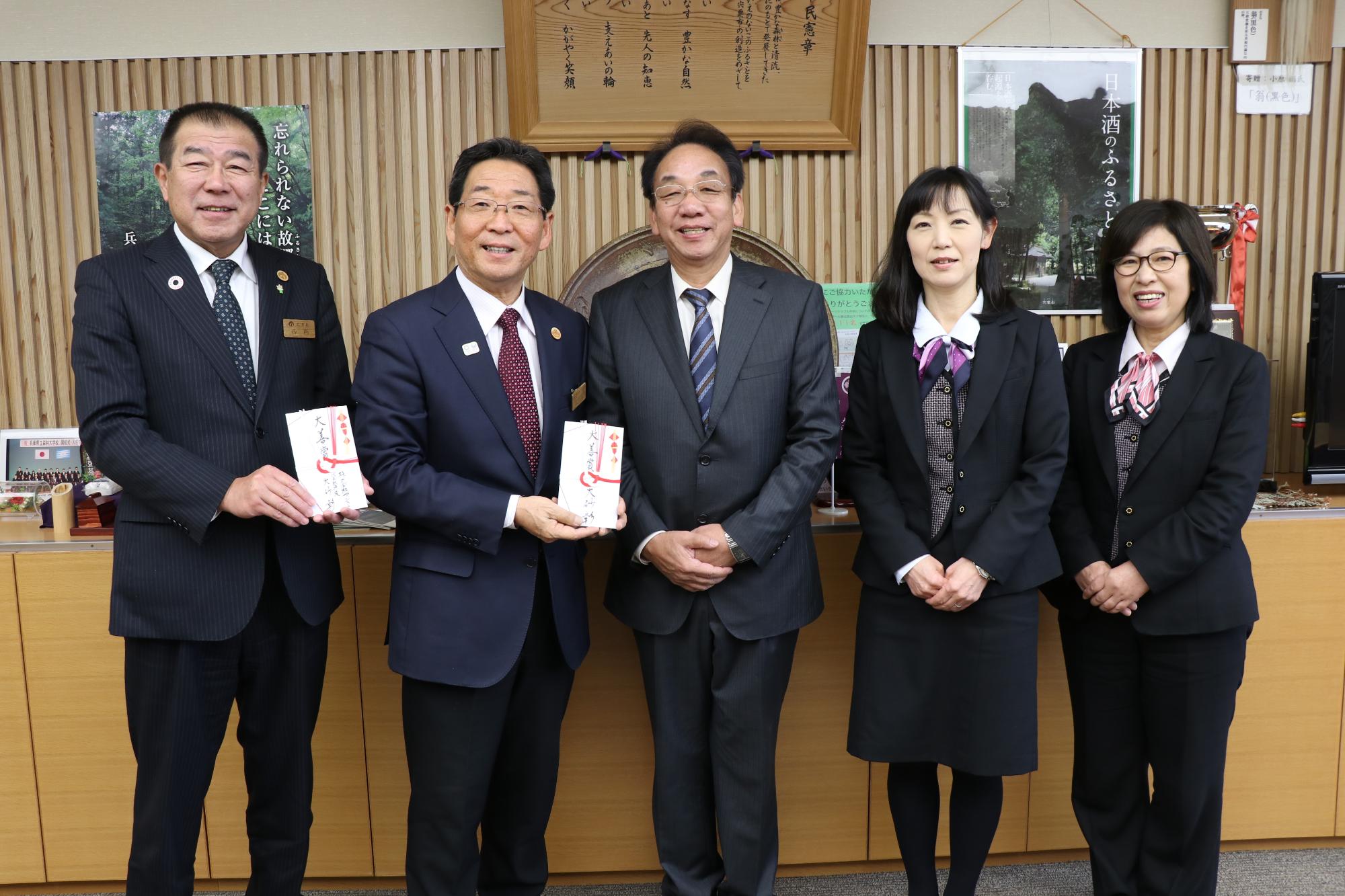 大砂氏と株式会社アシストの社員らと並ぶ市長と教育長の写真