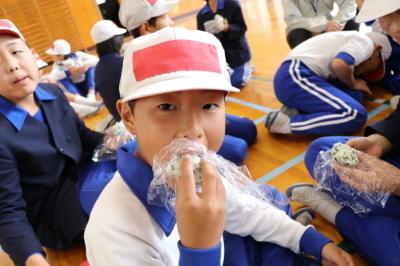 アルファ化米のおにぎりを食べる小学生達の写真