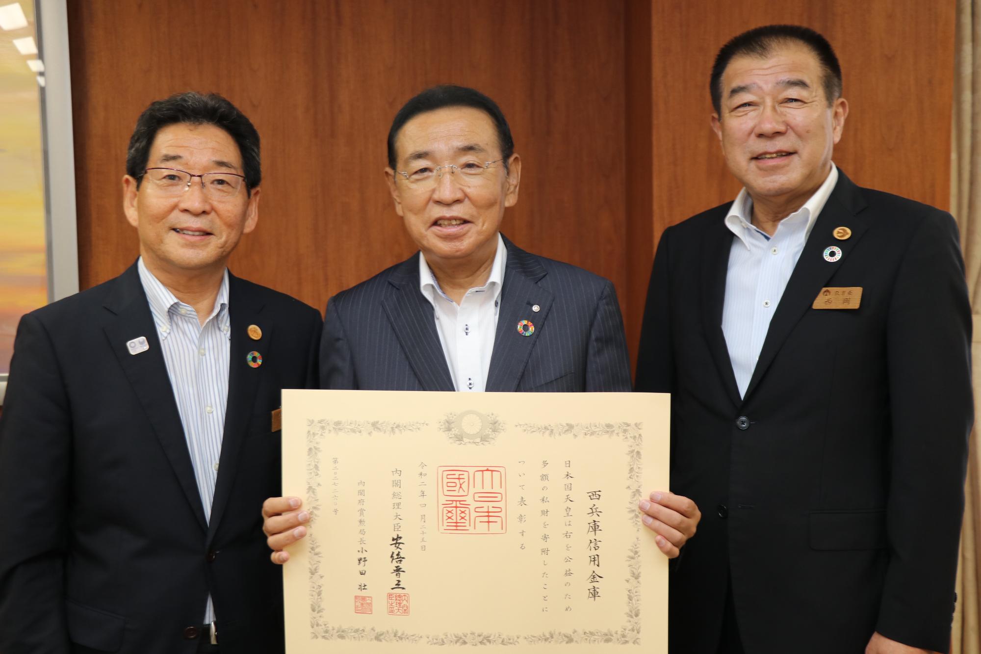 左から福元市長、褒状を持つ西兵庫信用金庫志水理事長、西岡教育長の写真
