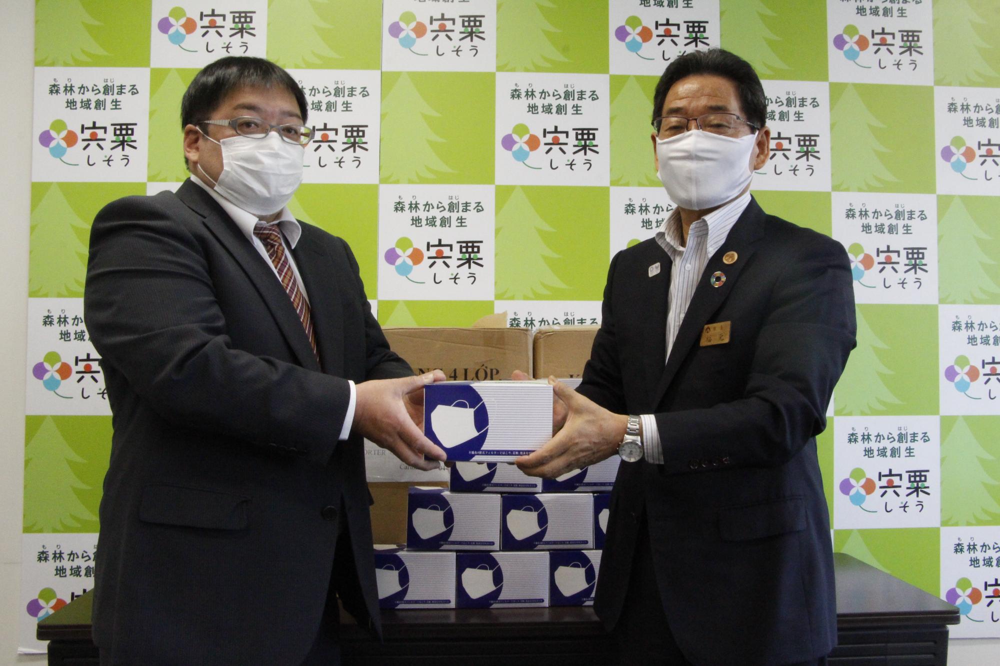 福元市長が株式会社スポーツクラブ報徳の伊藤さんからマスクを受け取っている写真