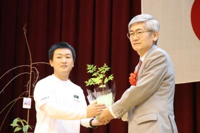 記念樹を持つ学生と兵庫県知事の写真