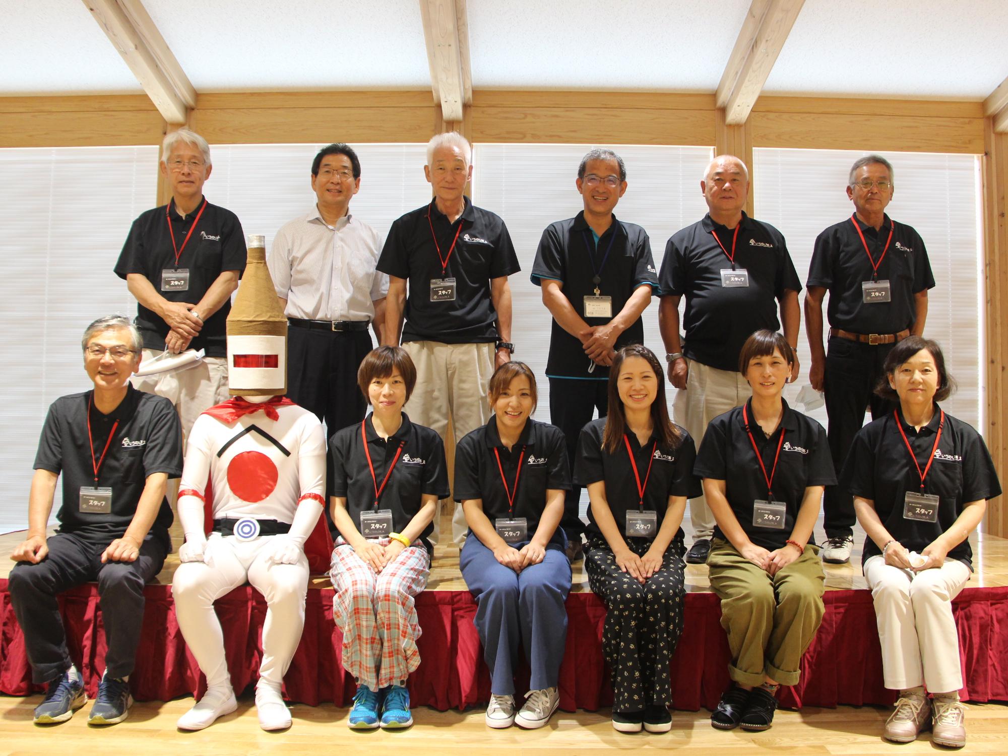 上段左から二番目に市長、下段左から2番目に日本酒マンを迎え、運営検討協議会委員との集合写真