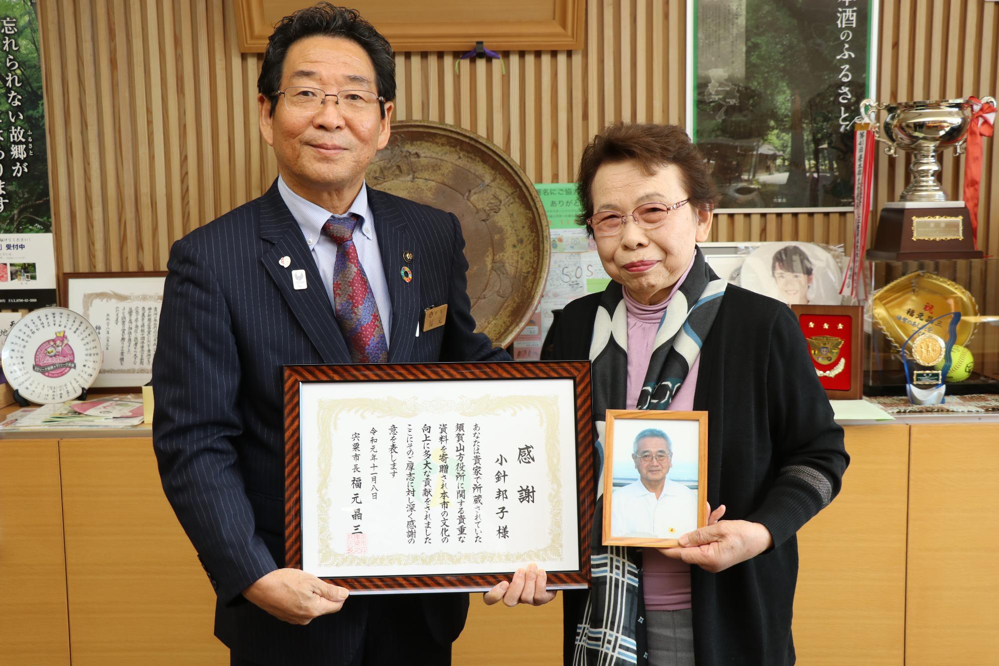 感謝状を持った小針さんが市長と並んでいる写真