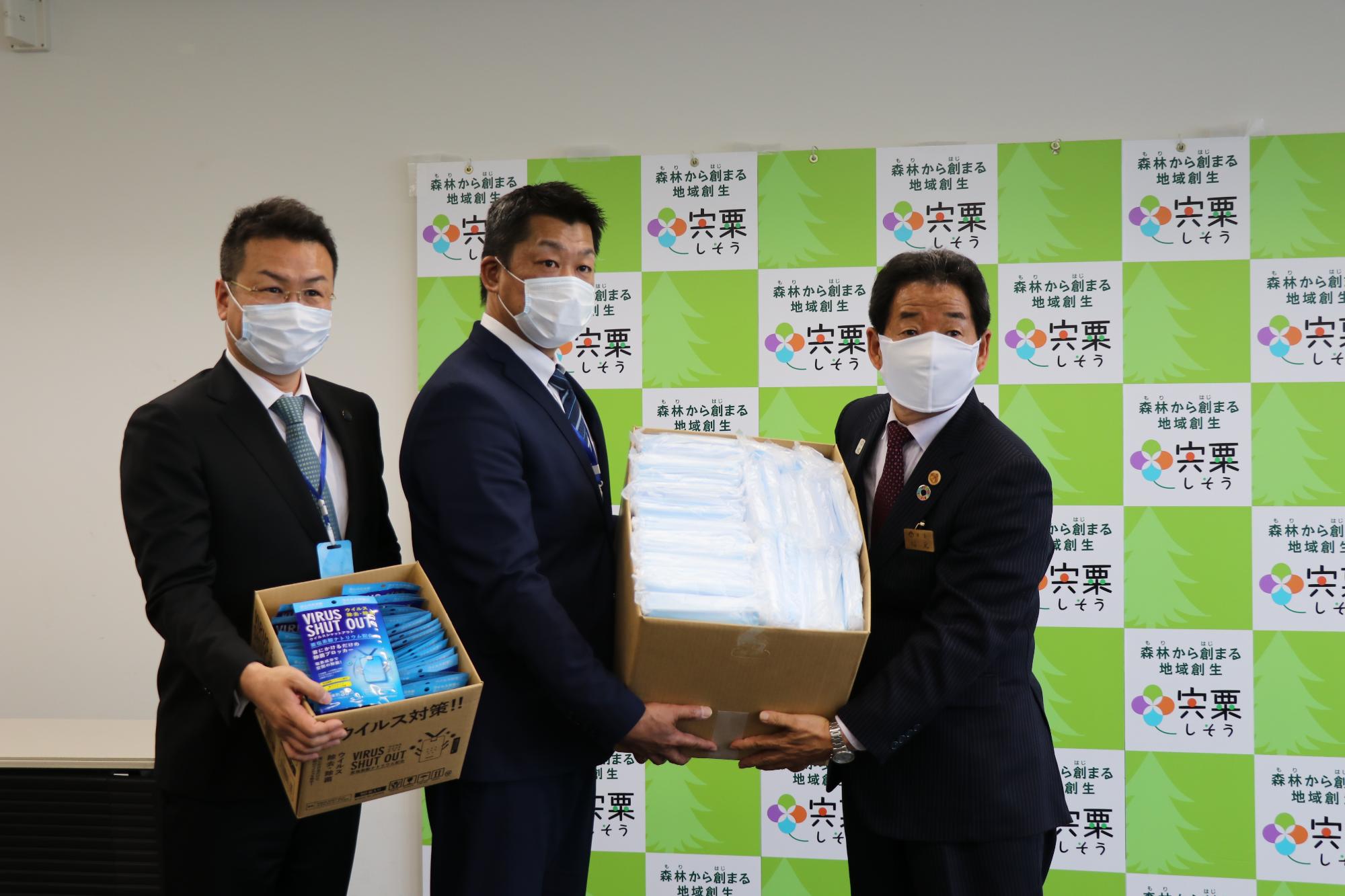 ロイヤルニッポン財団の毛利氏と小倉氏からマスクを受け取る市長の写真