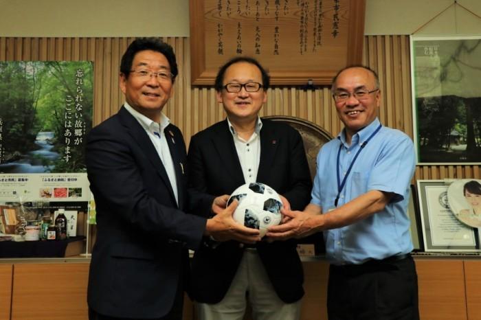 市長と三木谷さんともうひとりの男性が寄贈したサッカーボールを手にしている記念写真