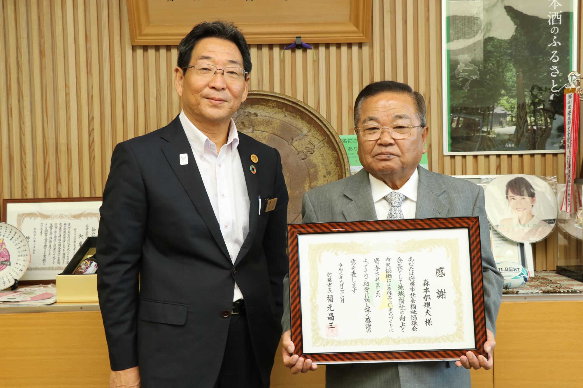 感謝状を手に笑顔を見せる森本さんと市長が並んでいる写真