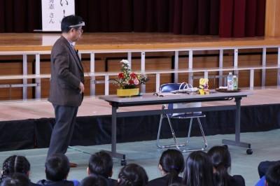 脳波製品を披露する大西秀憲さんとそれに驚く小学生達の写真
