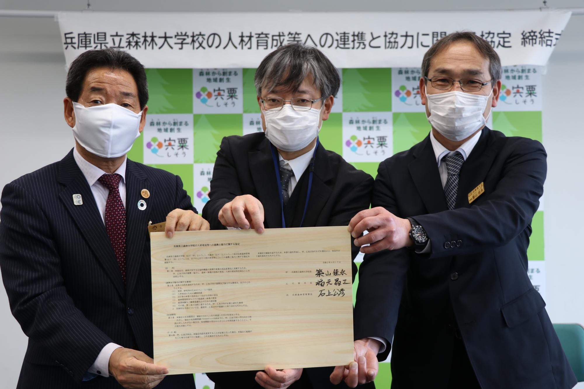 左から福元市長、森林管理署長、森林大学校長が署名した協定書を手にしている写真