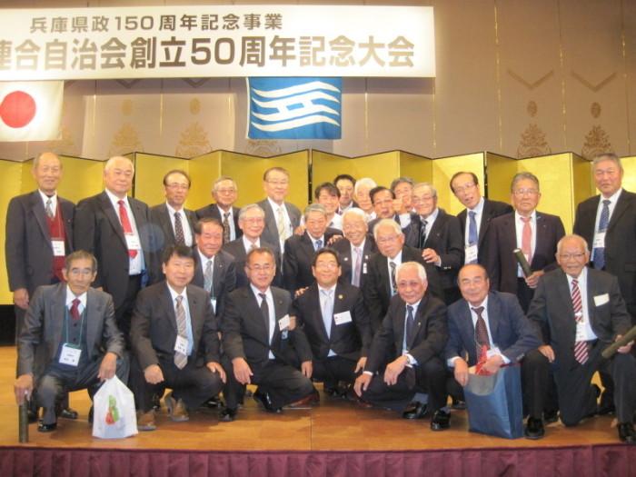 20名以上のスーツ姿の自治体代表者らが写る兵庫県連合自治会記念大会の記念写真