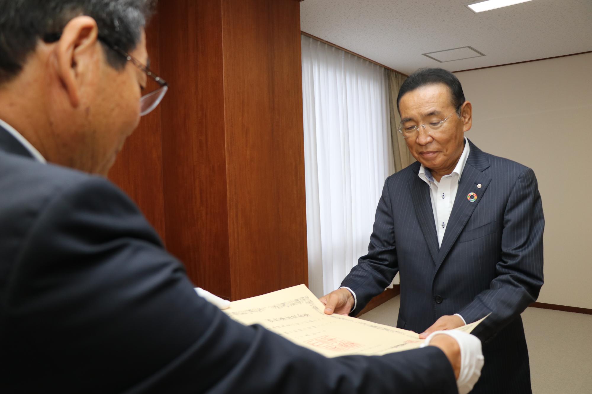西兵庫信用金庫志水理事長が紺綬褒章の褒状を市長から受け取る写真