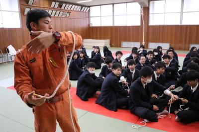 消防隊員の指導のもとロープワーク訓練を学ぶ山崎高等学校の生徒達の写真