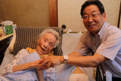 最高齢者の橋本さんと福元市長が握手をしている写真
