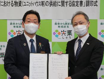 三協フロンテア株式会社荻久保昇さんと協定書を掲げる福元市長の写真
