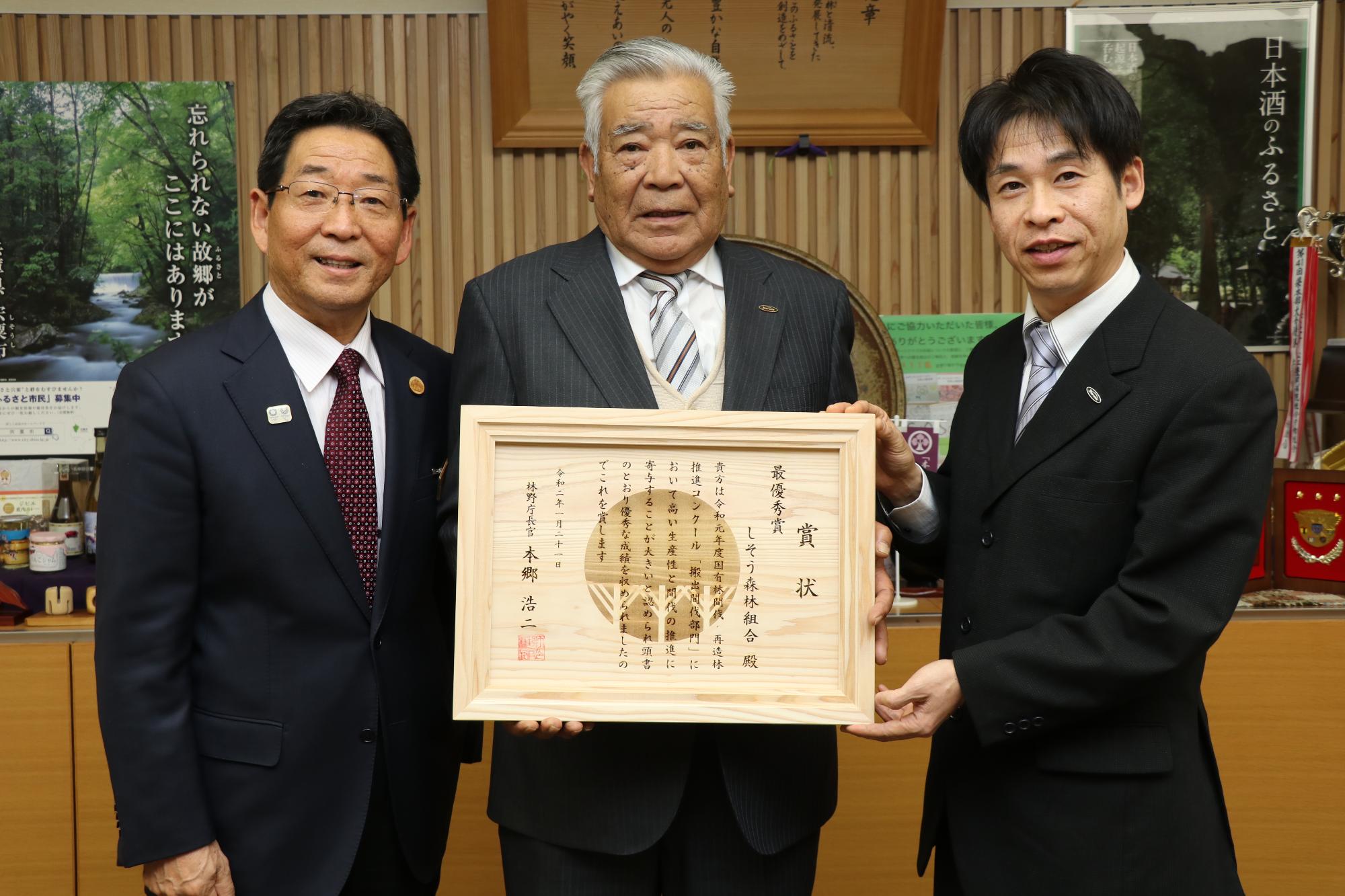 表彰状を持った宍粟森林組合長同組合の職員、市長の3人がが並んでいる写真