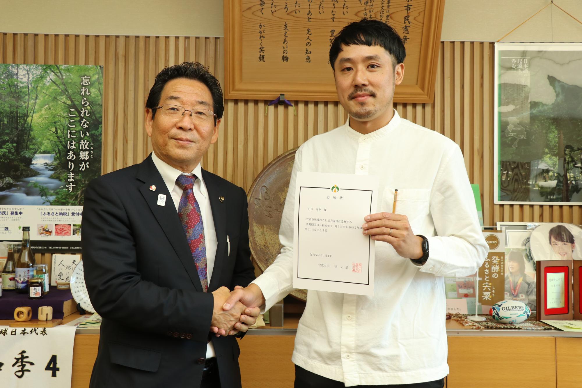 地域おこし協力隊の山口隊員と市長が握手を交わしている写真