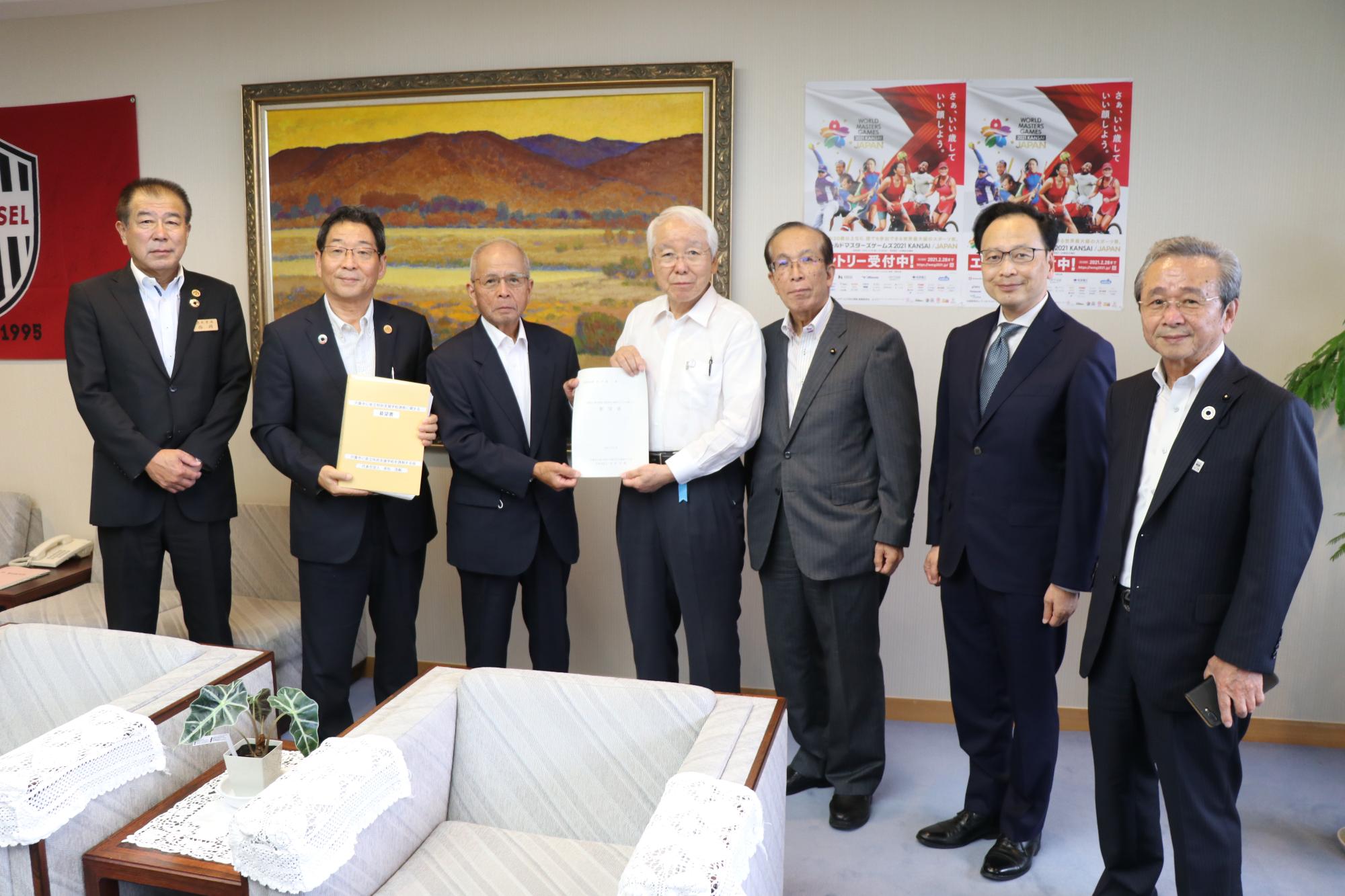知事室にて左から西岡教育長、福元市長、要望書を手にする赤松氏と井戸知事、右端に春名県議会副議長の写真