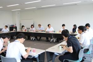 市役所会議室で向き合って座る市職員達が弁当を食べている写真