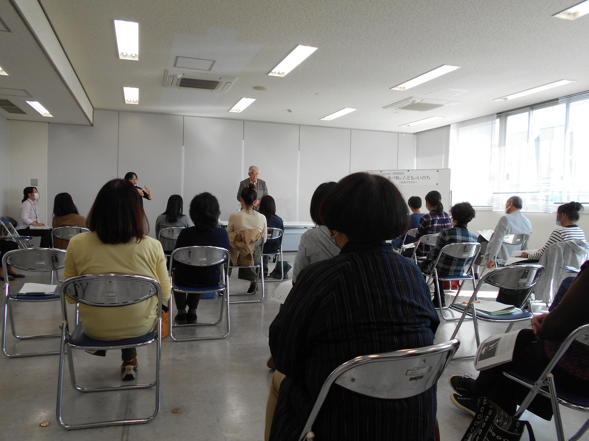 会議室で会員が食育に関する講演会を聞いている写真