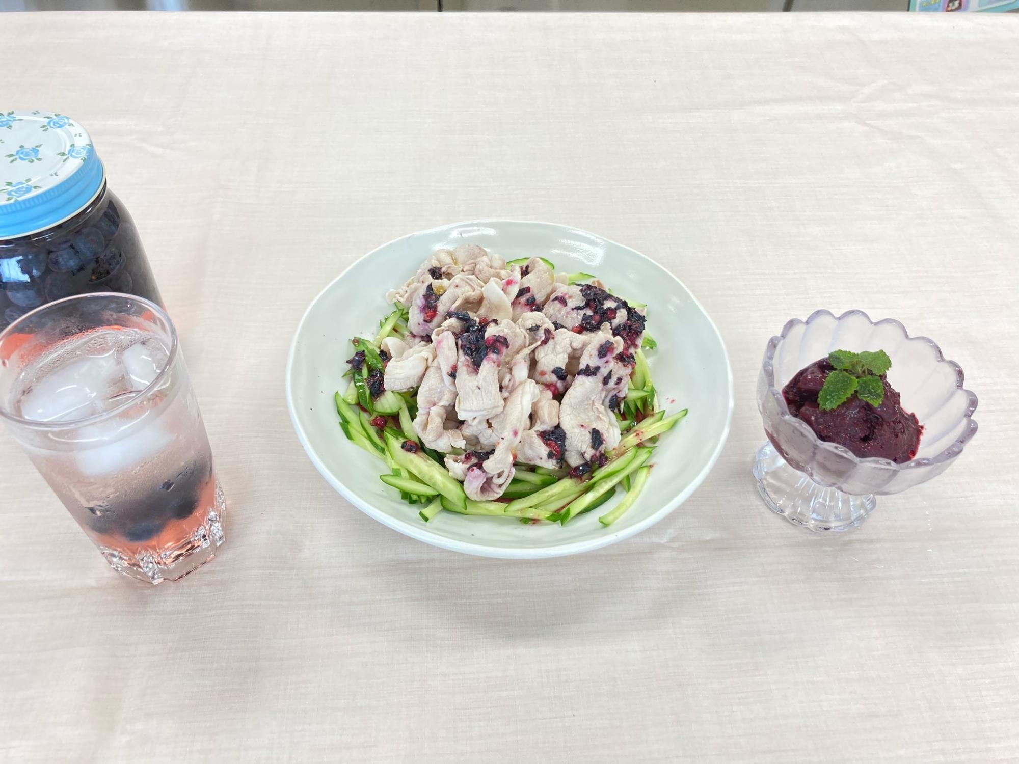 ブルーベリーを使用したサラダや飲み物が食卓テーブルの上に並んでいる写真