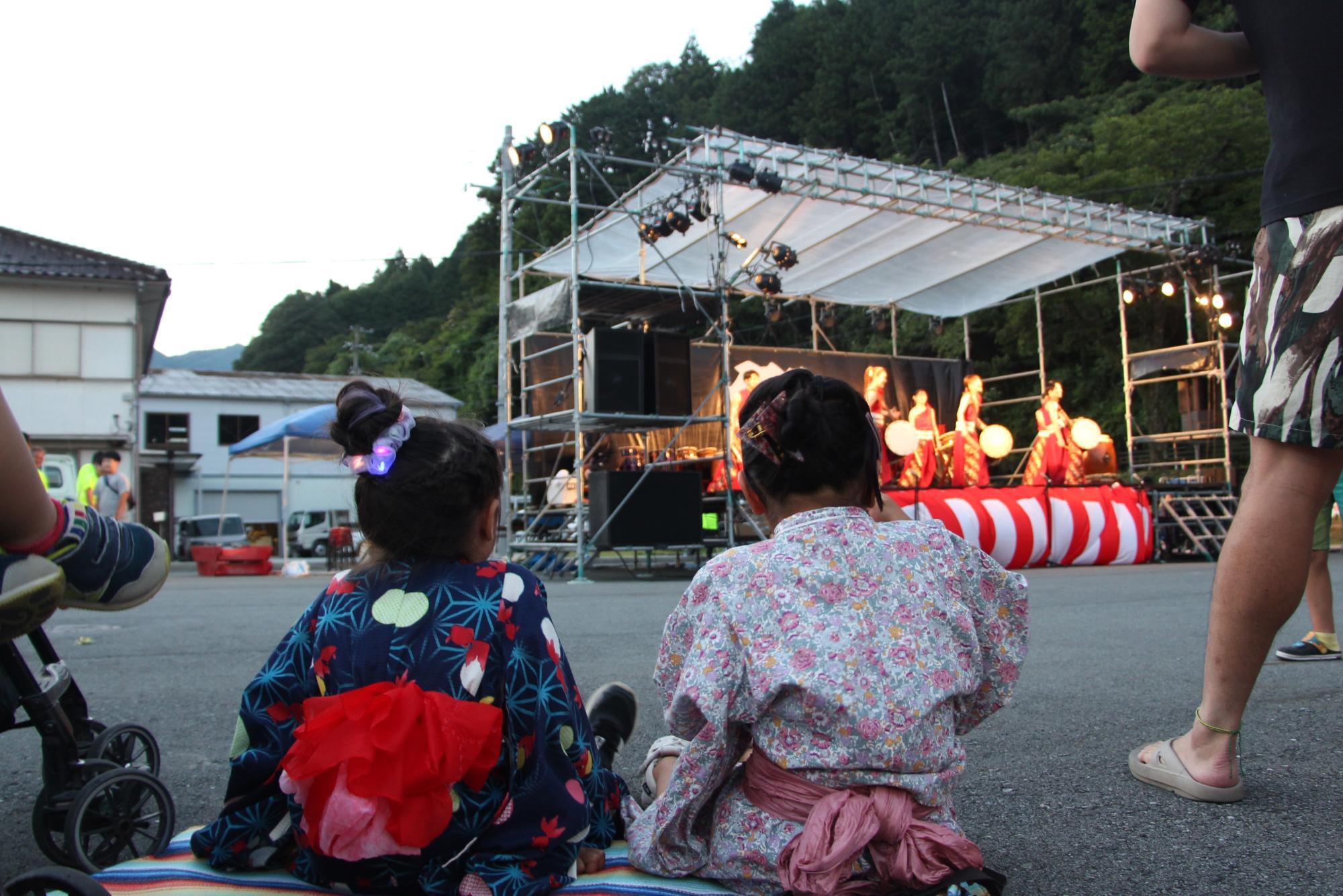 和太鼓パフォーマンスを観ている浴衣を着た子どもたち