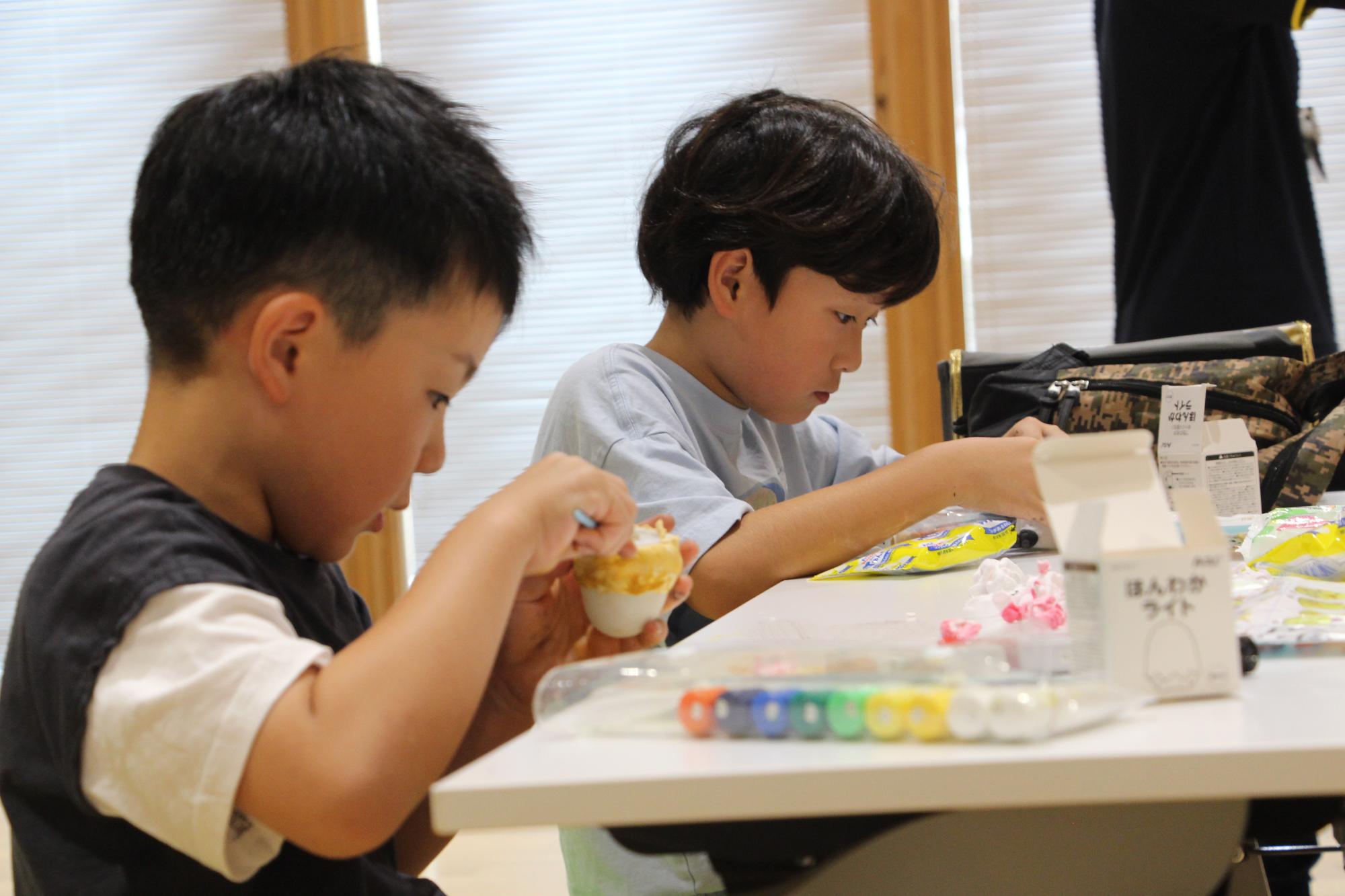 真剣な表情でライトに黄色の粘土を張り付ける参加者