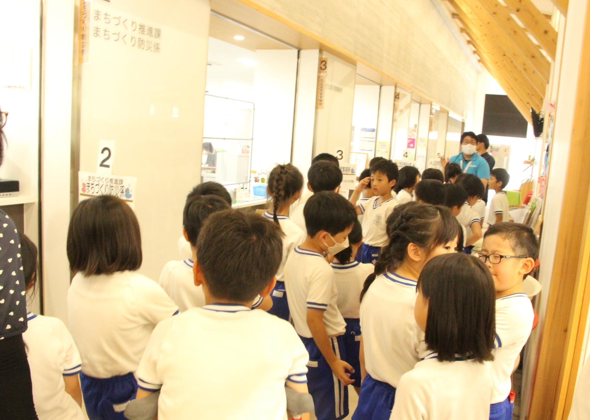 いちのぴあの事務室前にはりま一宮小学校2年生と担当教諭が集まり、市の職員から施設の説明を受けている写真