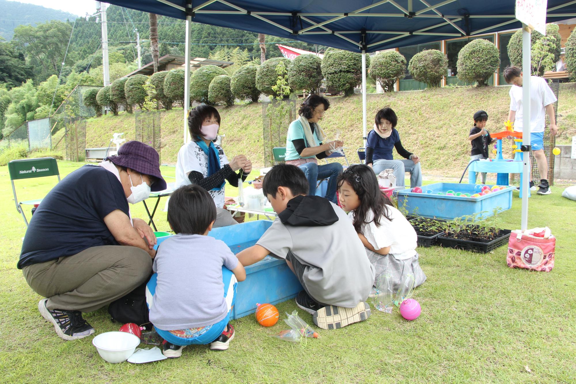 縁日コーナーでヨーヨー釣りを楽しむ子どもたちの写真