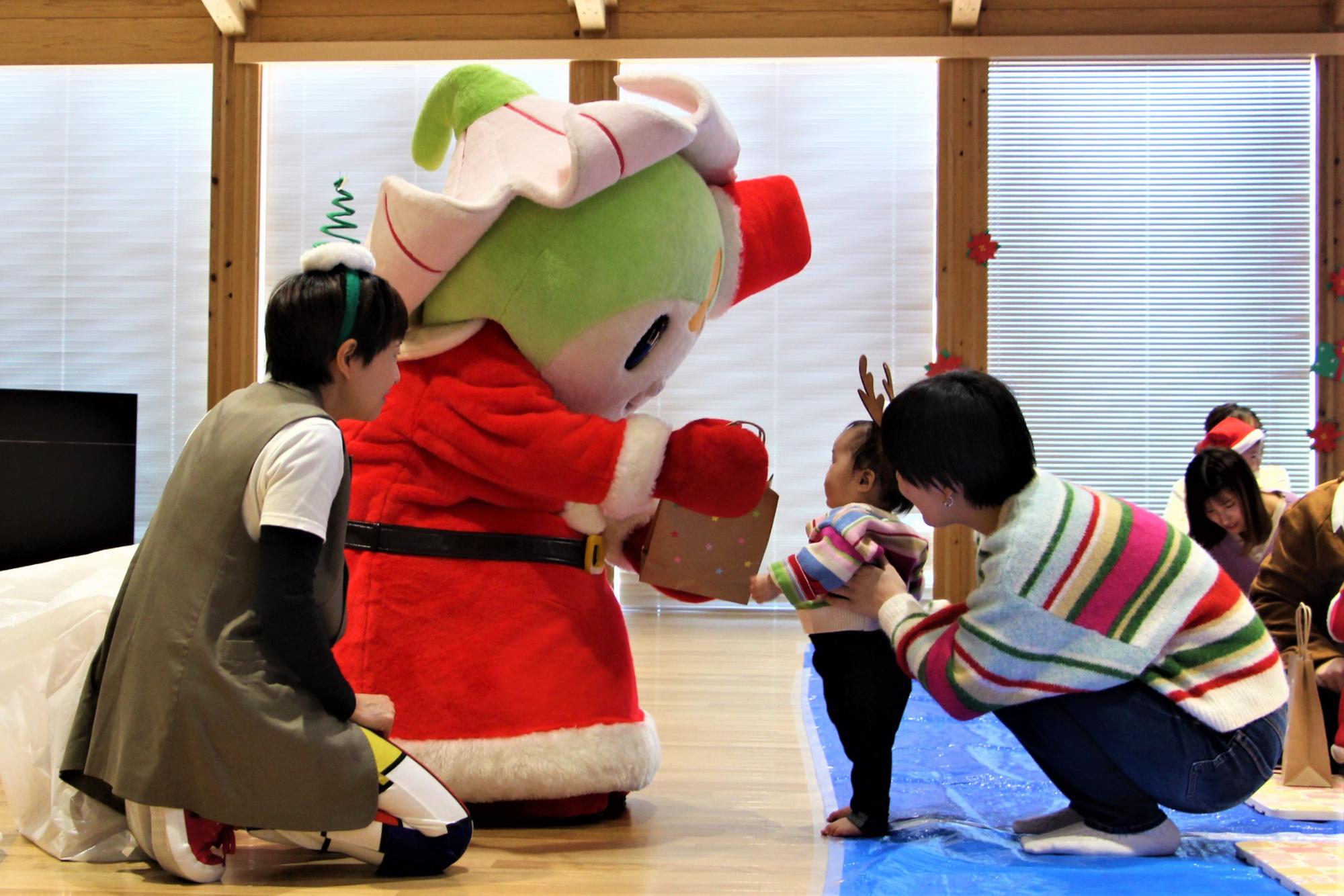 赤ちゃんがしーたんからプレゼントをもらっている様子