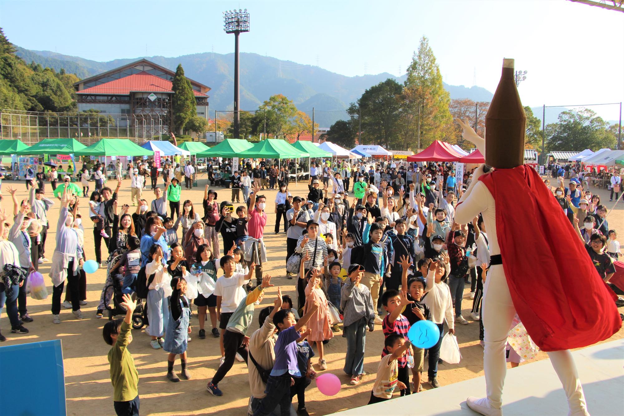 じゃんけんで勝ち残ると景品がもらえるイベントで、ステージ上の日本酒マンと来場者がじゃんけんしている写真