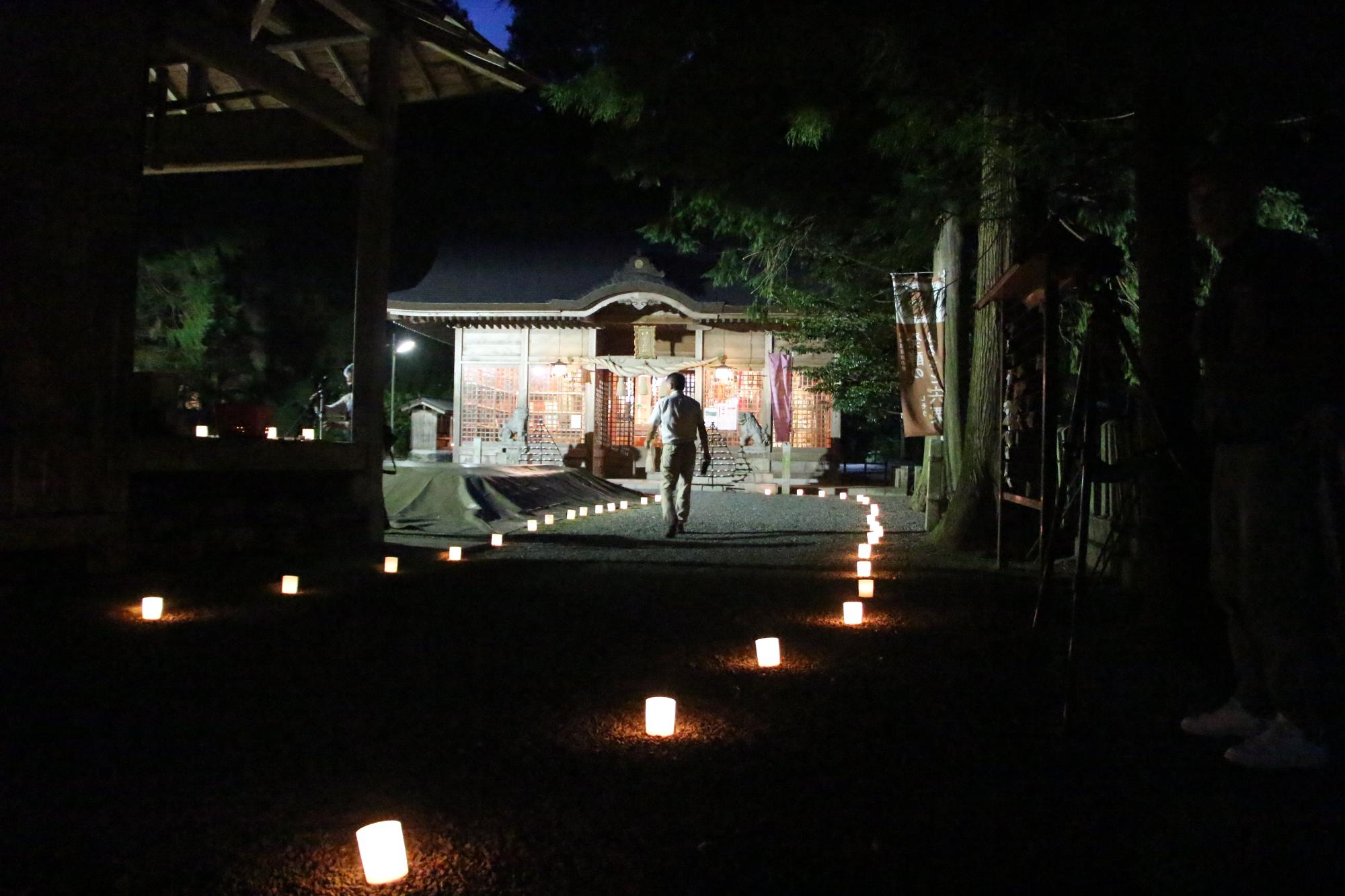 庭田神社本殿までの参道の両脇に灯明が並び神社を幻想的に照らしている写真