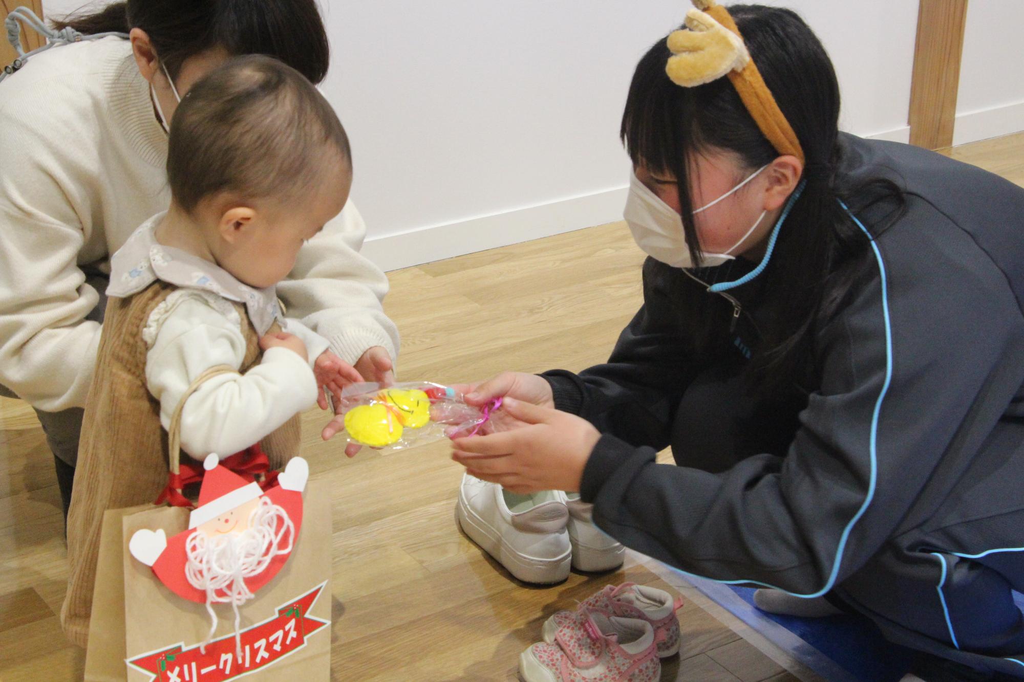 伊和高校の生徒からクリスマスプレゼントを受け取る子どもの写真