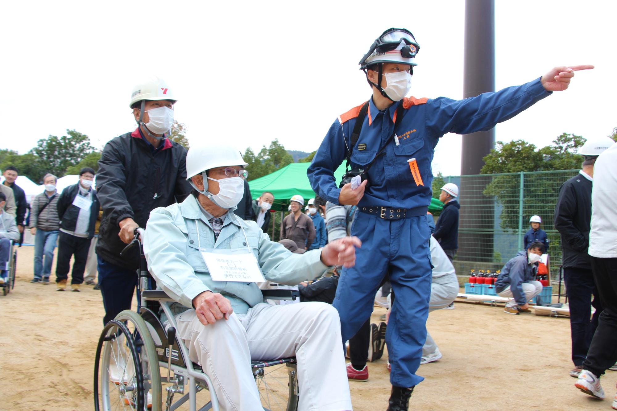 応急救護訓練で足を負傷した被災者役の男性を誘導している写真
