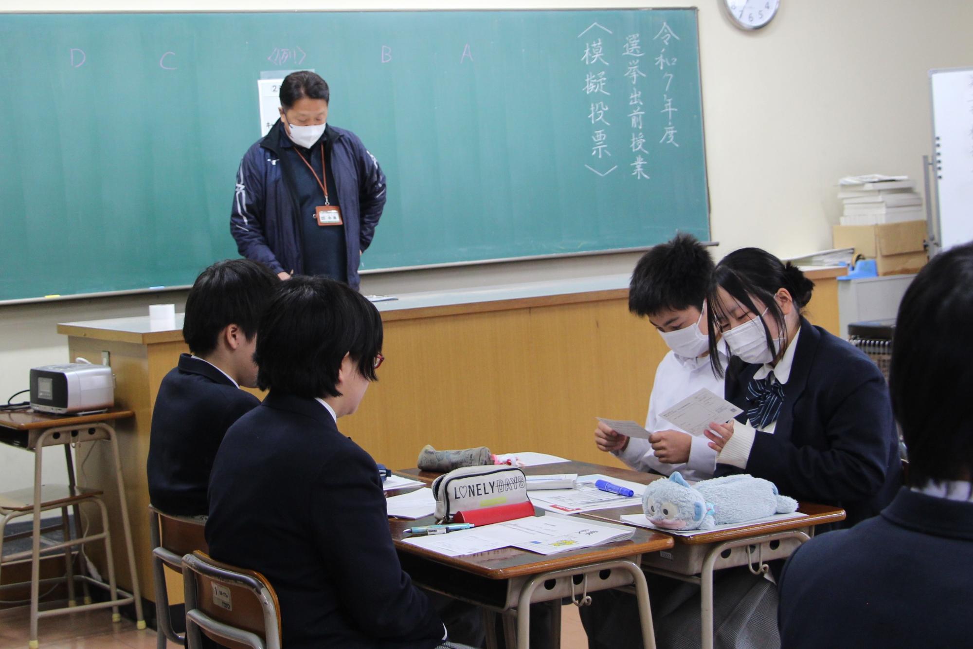 模擬投票で使う選挙のお知らせ券を生徒が確認している様子